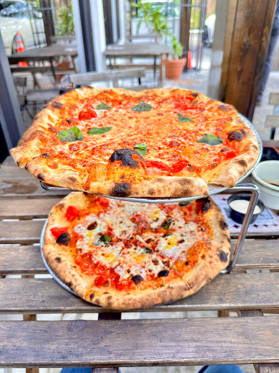 two pizzas on a wooden table